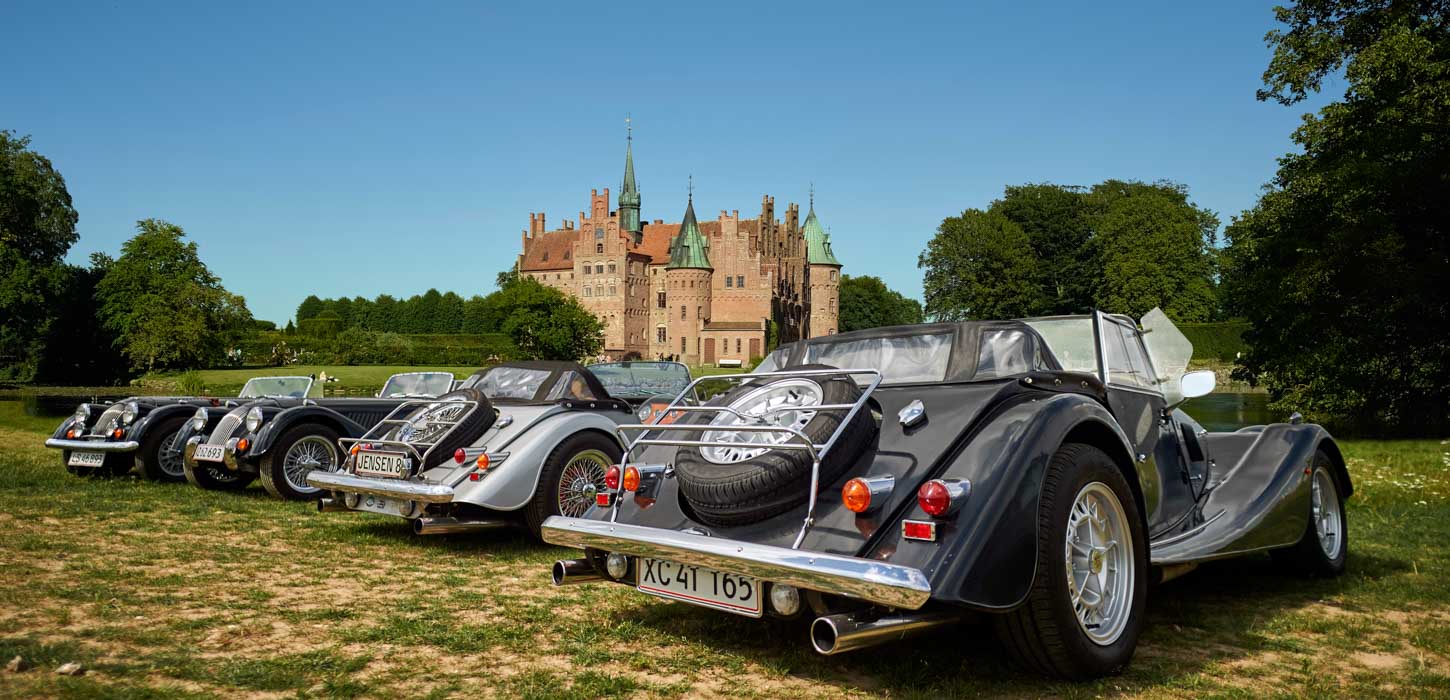 Fire veteranbiler i forgrunden. Egeskov Slot i baggrunden.