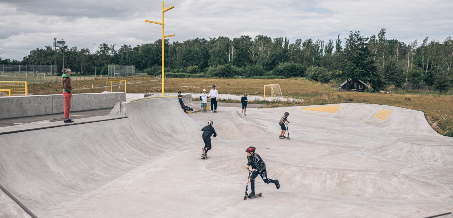 Stor multipark med børn, der står på løbehjul og leger.