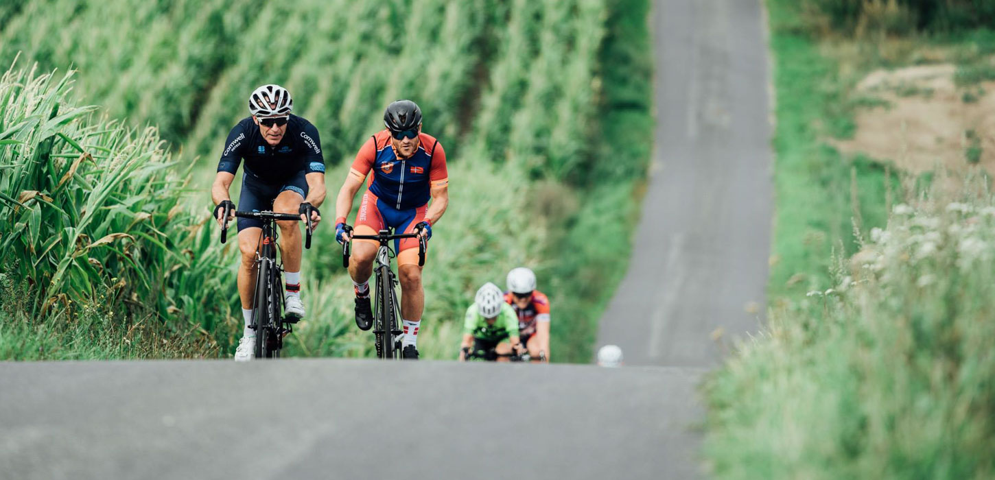 Cykelryttere på vej op ad stejl bakke.