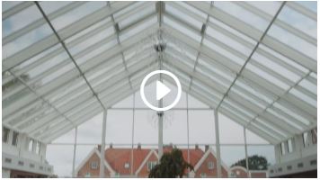 Loftet af et orangeri hvor en virtuel afspilningsknap er sat ind over