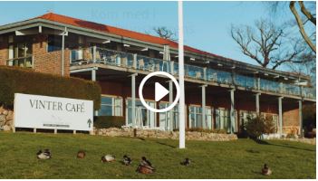 Billede af Hotel Christiansminde bag deres flagstang. Indover billedet er sat et videoikon. 