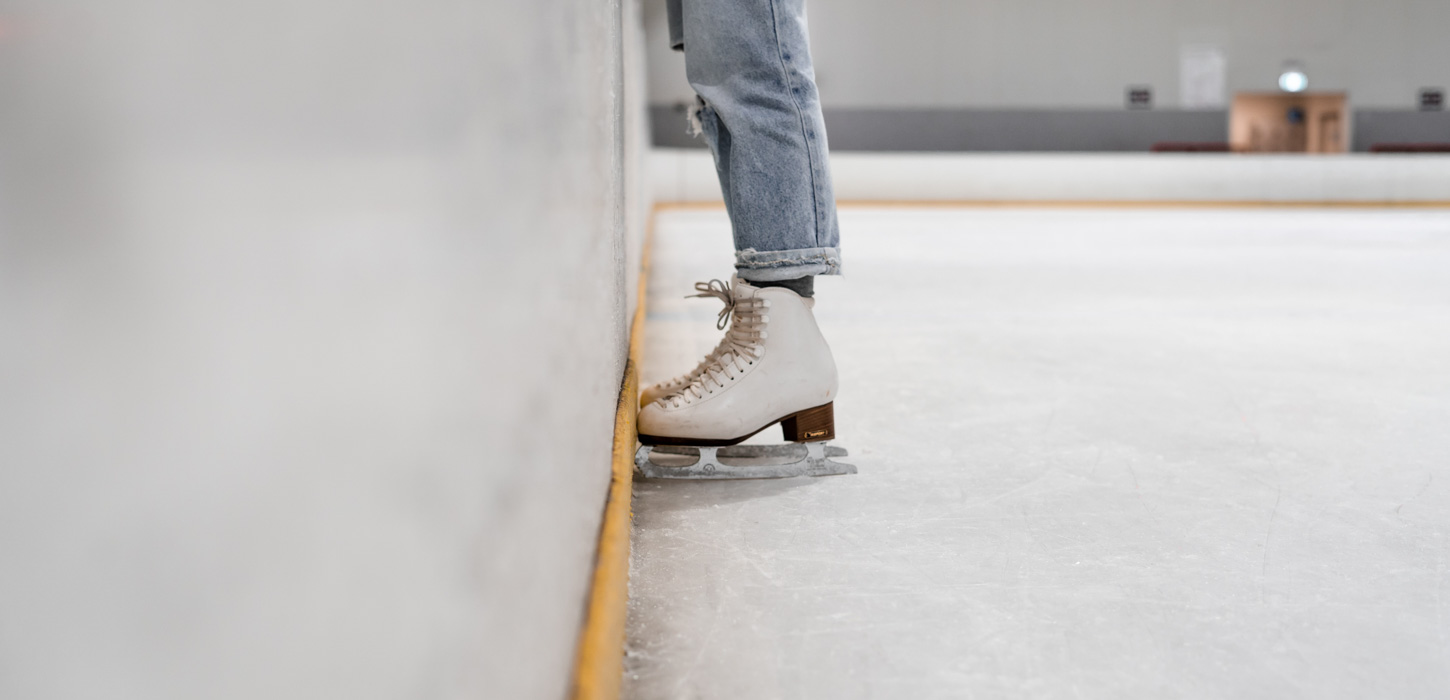 Et par skøjter med et par ben i står op ad en væg.