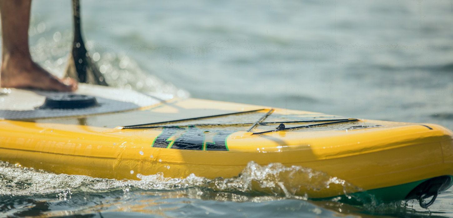 En person på gult stand up paddle board 