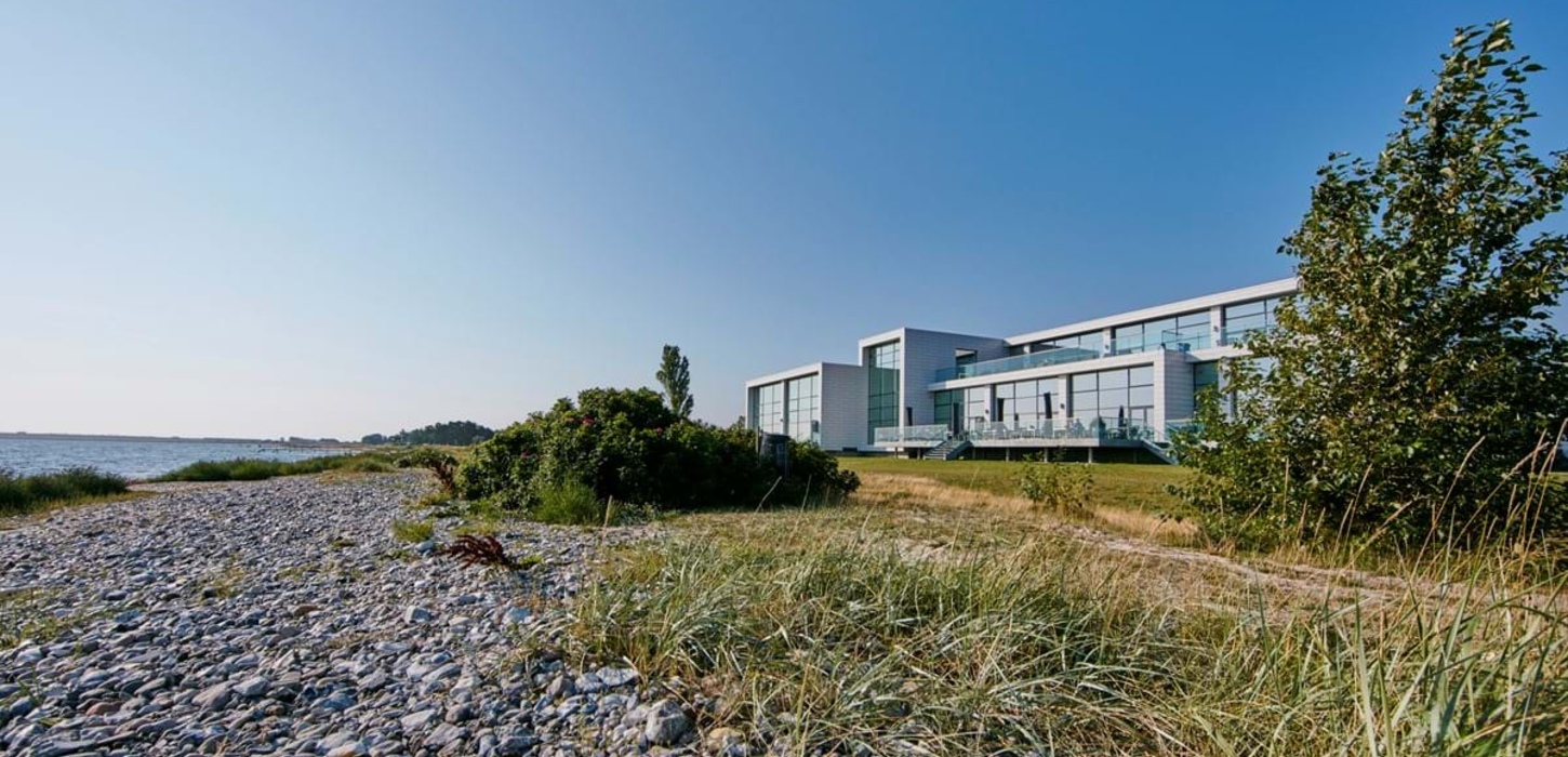 Hvidt hotel beliggende ud til stranden.