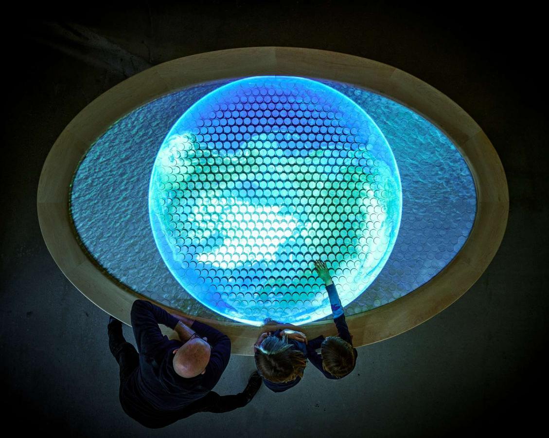 Far og to børn står ved bord på Øhavsmuseet. Bordet viser en model, der viser Det Sydfynske Øhav fra istiden til i dag