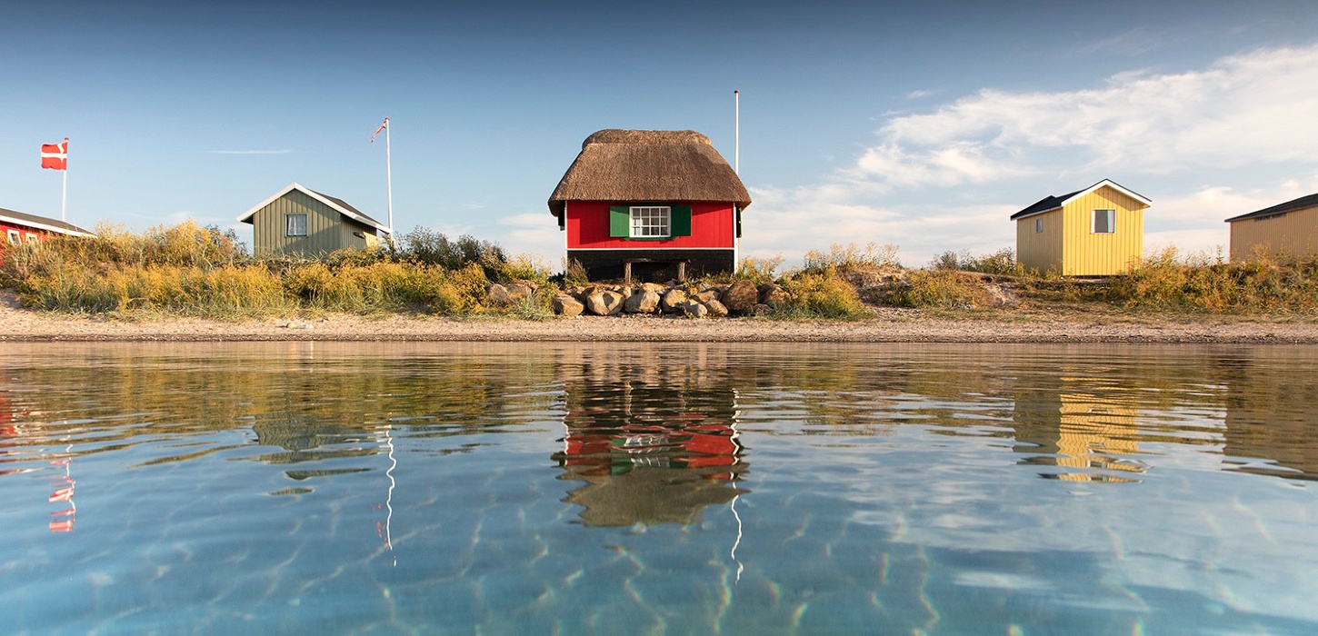 Tre badehuse ved Eriks Hale ved Marstal. Blå himmel og blåt vand.