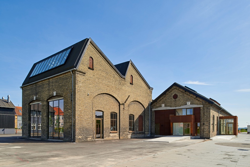 Stort bryggeri i mursten under en blå himmel. 