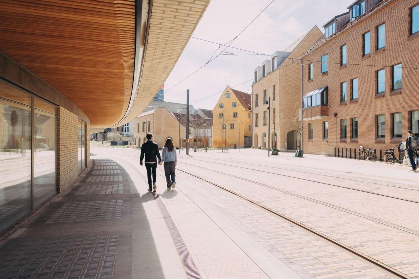 Et par går hånd i hånd langs med letbanens tracé i Odense bymidte.