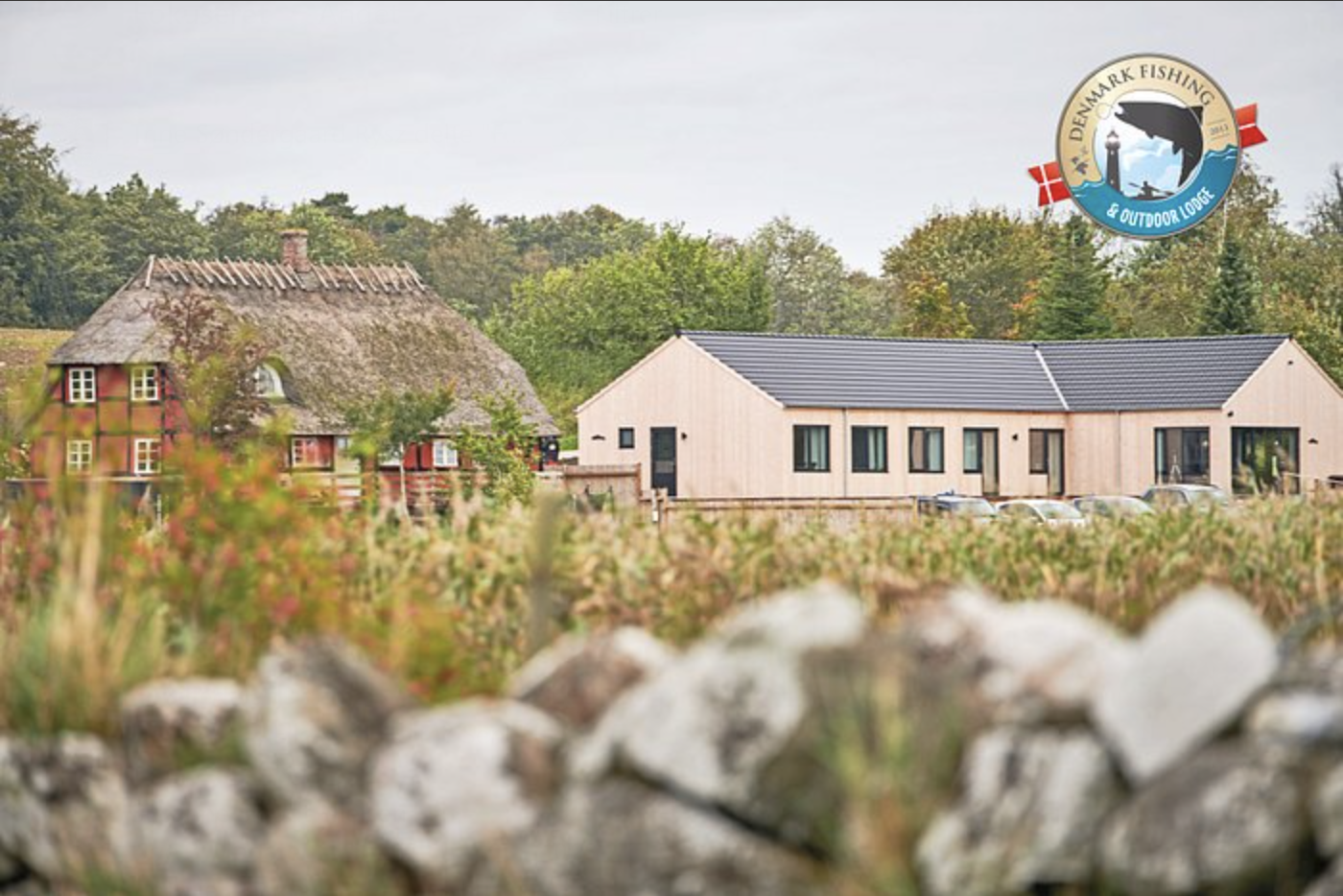 Man kan se Danmarks Fiskelodge og i baggrunden er skoven. Deres logo er vist i øverste, højre hjørne.