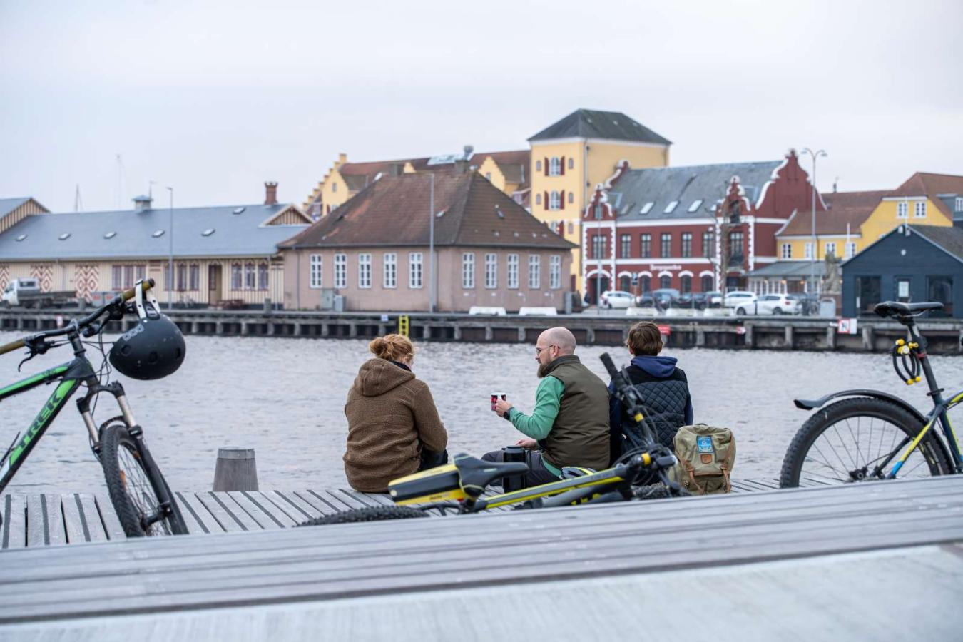 Tre cyklister holder pause ved Svendborg Havn. 