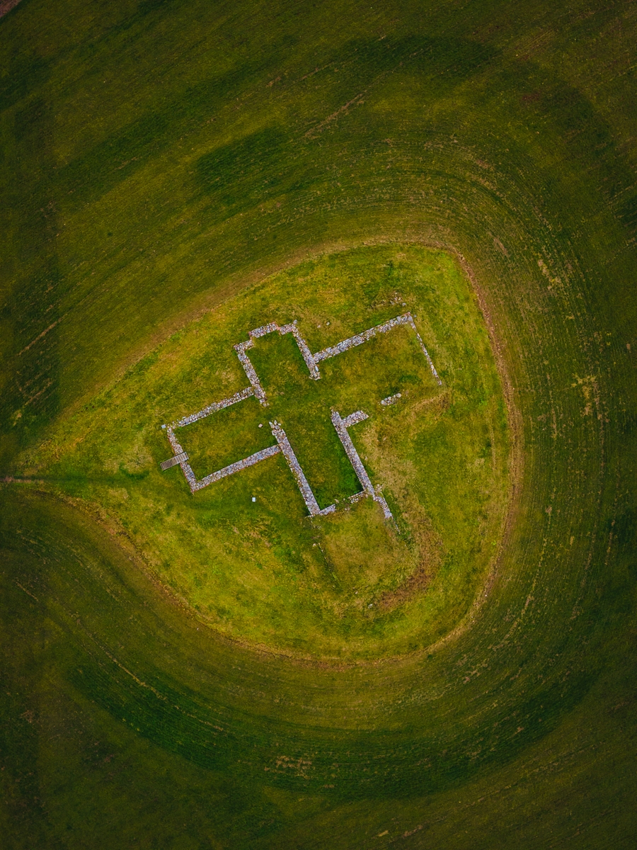 Luftfoto af Findstrup Kirkeruin. Et grønt område, hvor murbrokker danner omridset af den tidligere Findstrup Kirke.