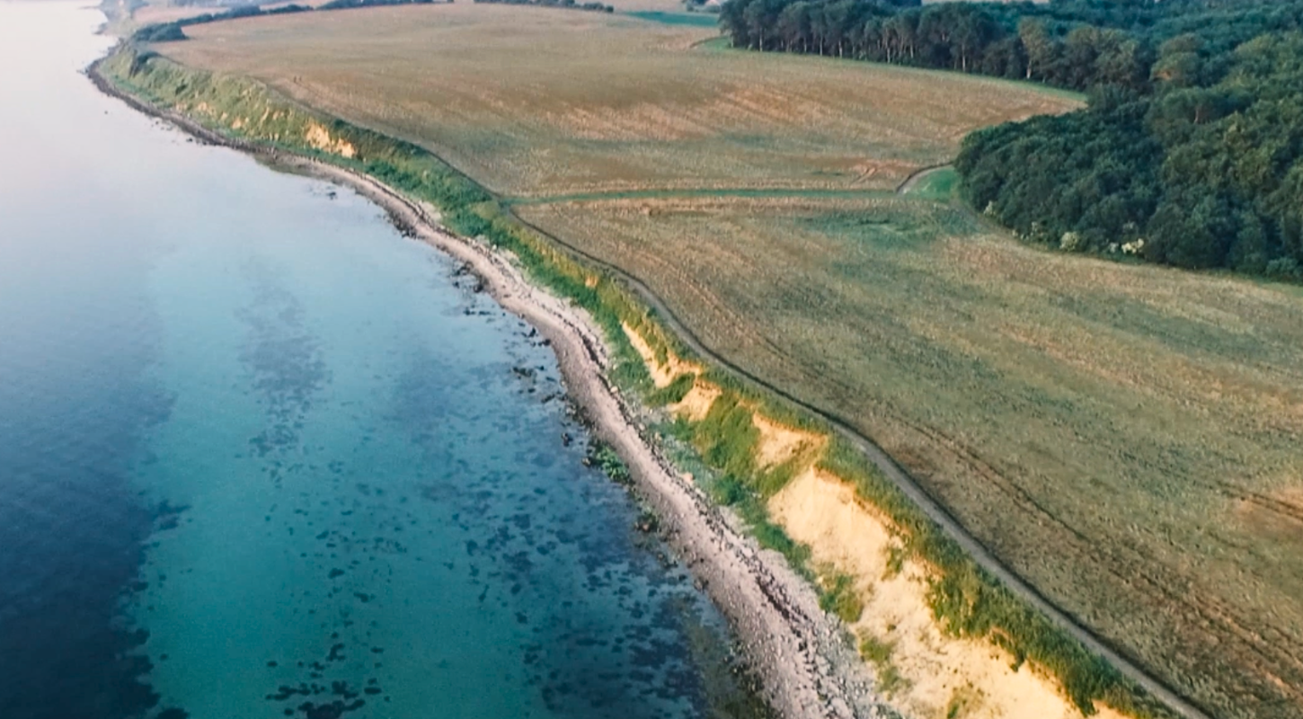 Et dronebillede af klint- og strandlandskabet beliggende ud til havet