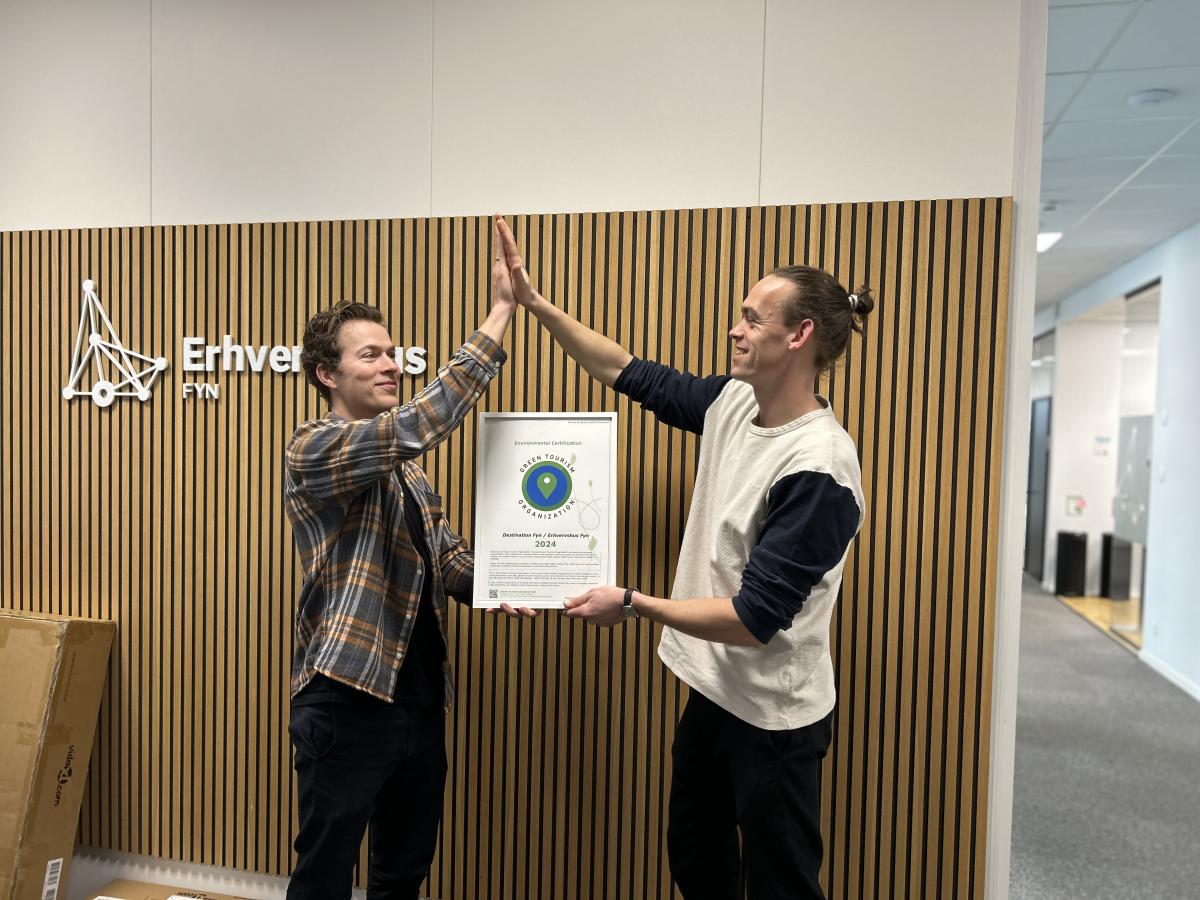 Destination Fyns Mark Hauge Østergaard og Erhvervshus Fyns Philip Eldridge giver highfive på, at GTO-certificeringen igen er i hus. 