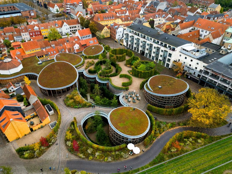 Dronefoto af H. C. Andersens hus, der består af en klynge af runde bygninger med mos på taget