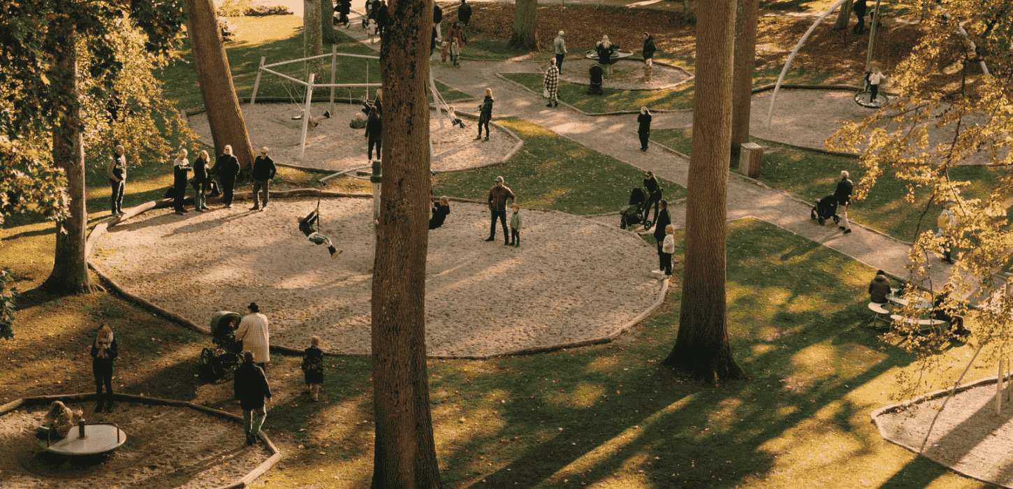Runde legepladser set fra oven i en skov i efteråret med gyldne blade på træerne