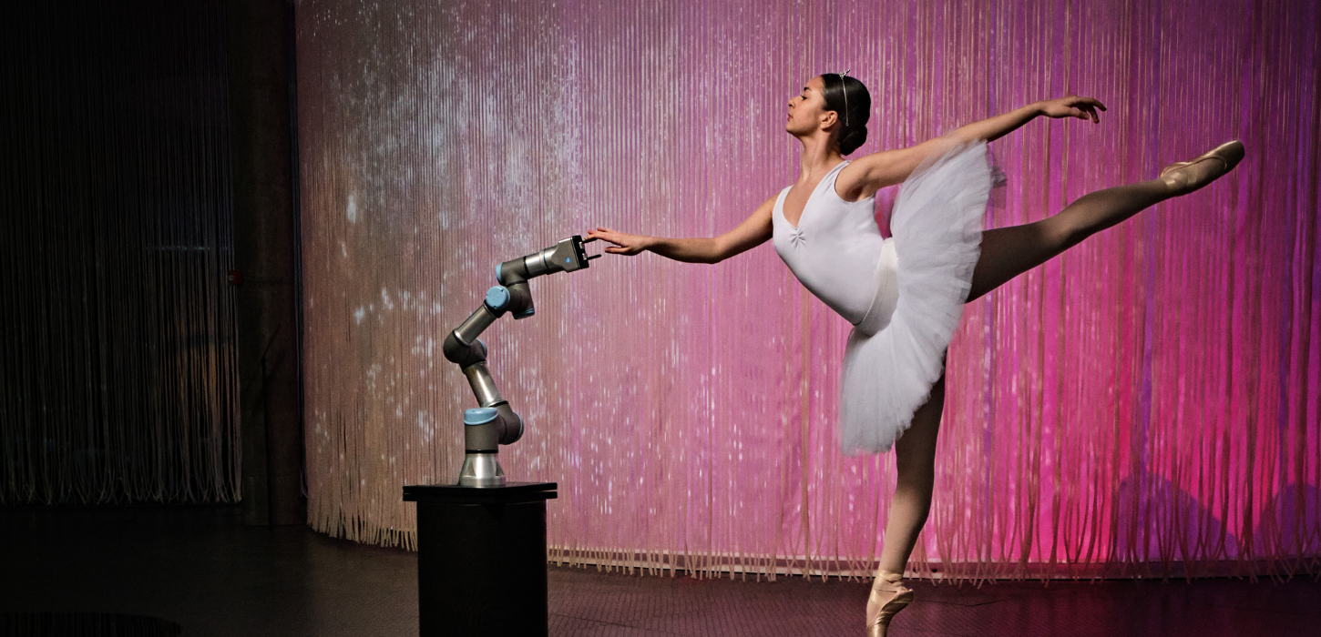 Balletdanser og robotarm oplyst af pink