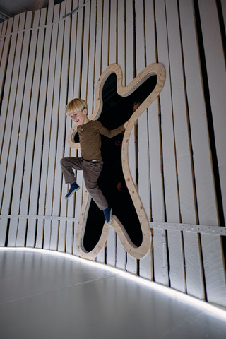 En dreng hopper igennem et hul i en væg