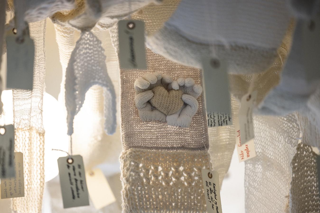 Forskellige strikkede udstillingsgenstande i lyse naturfarver