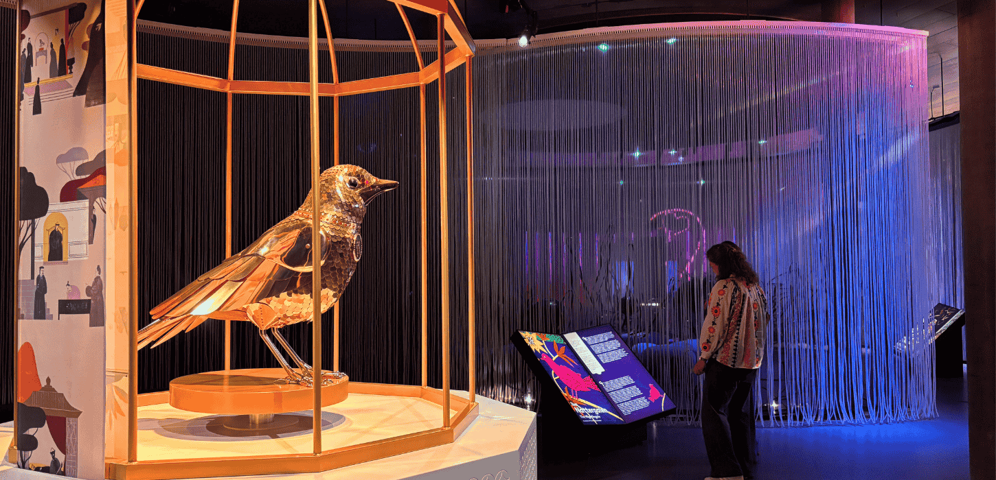 En kvinde står på en farverig udstilling og læser en lysende overdimensioneret bog