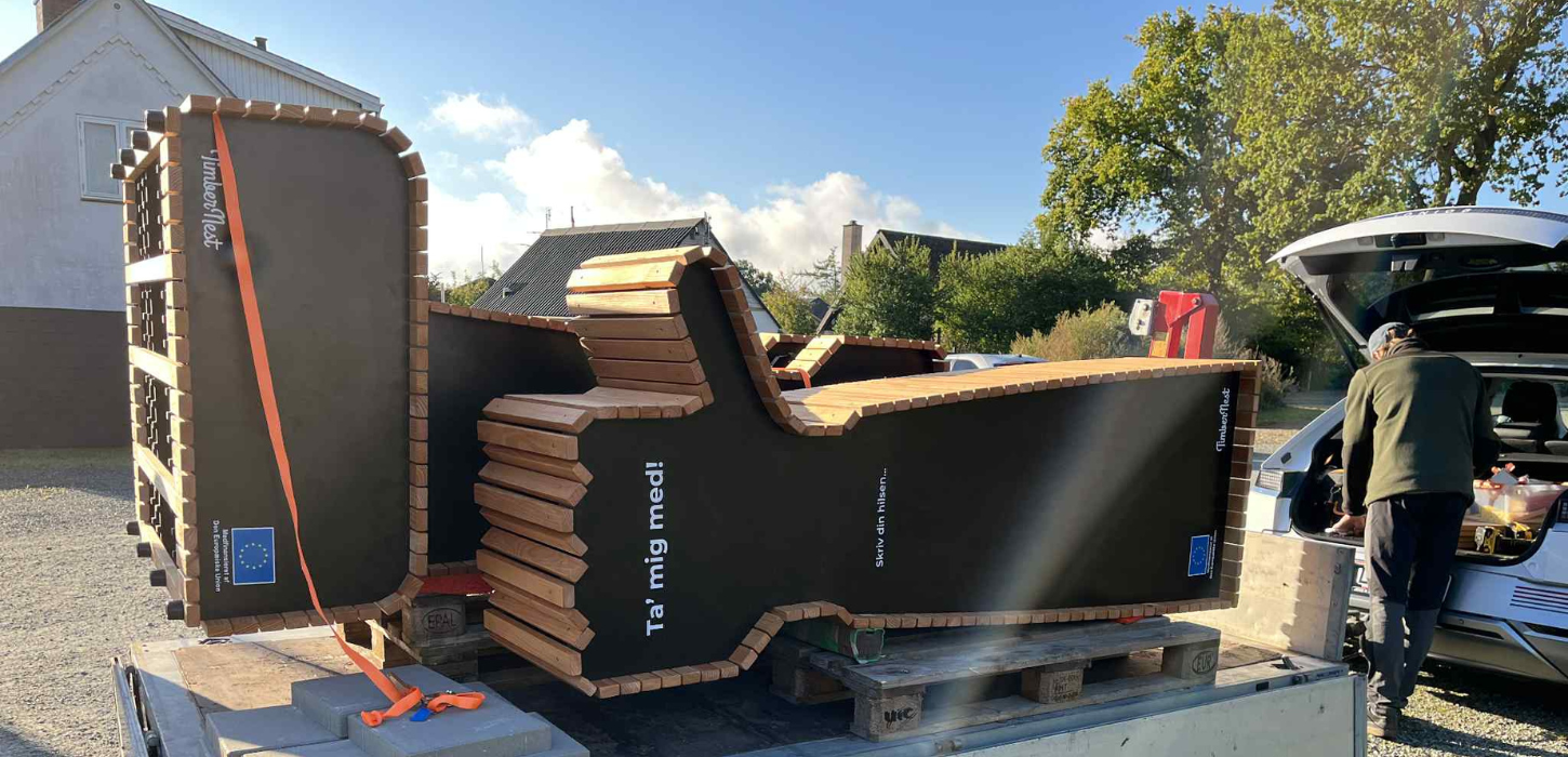 Blafferbænk med teksten "Ta' mig med!" på vej ned fra en trailer