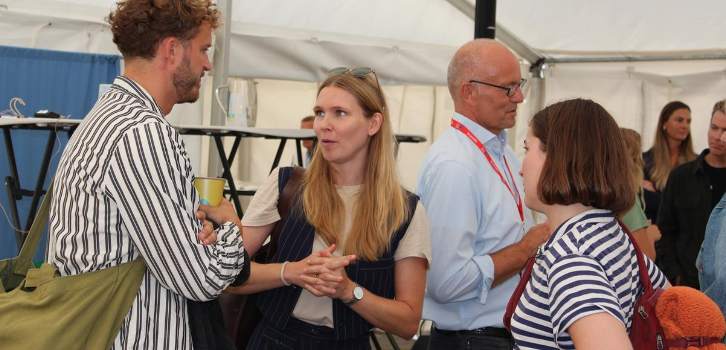 Fire mennesker står og taler med hinanden på kryds og tværs