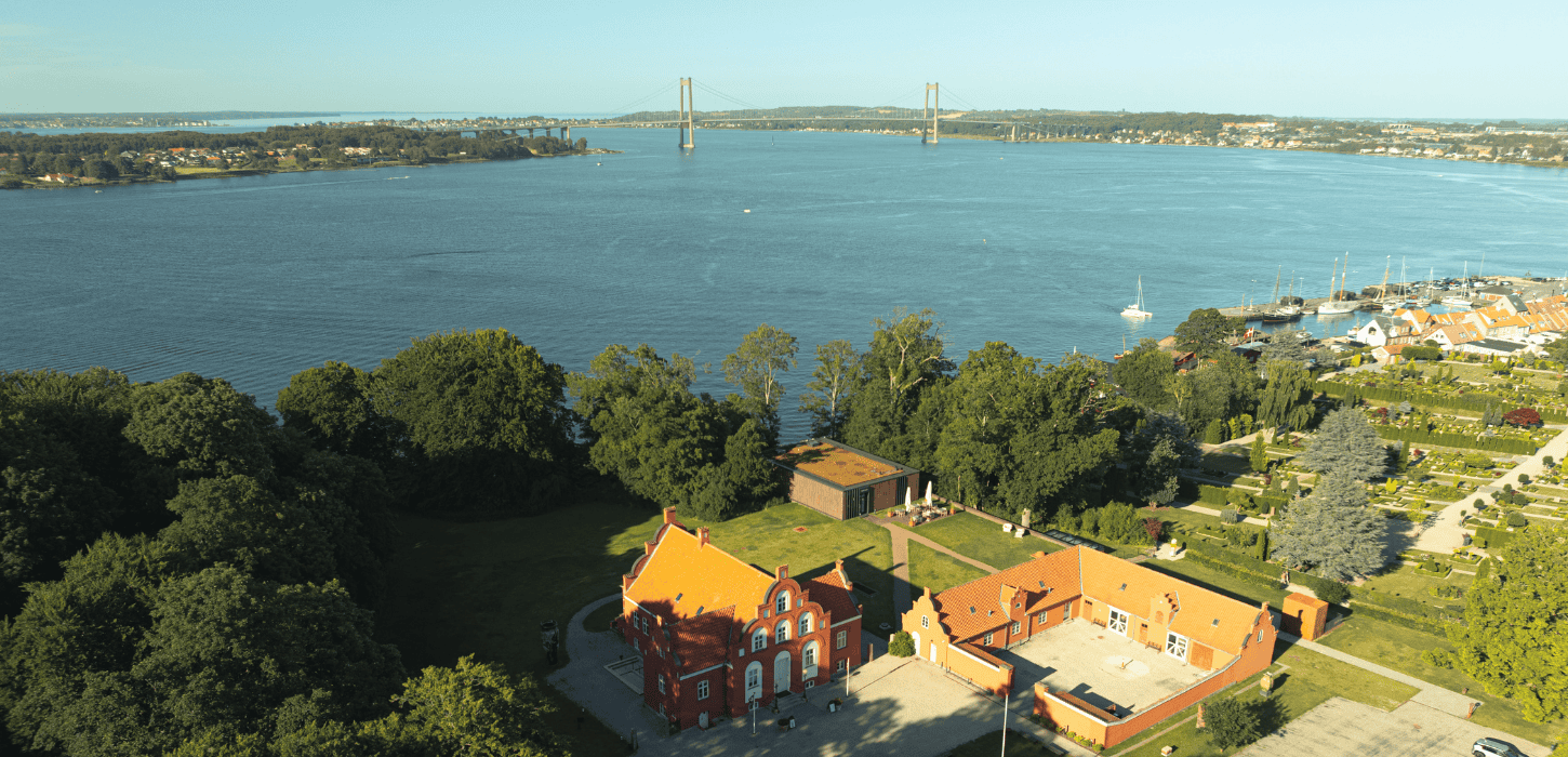Et luftbillede af lillebælt, den nye lillebæltsbro, keramikmuseet CLAY og den gamle havn i Middelfart