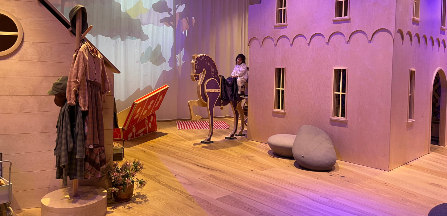 En lille pige sidder på en legetøjshest i Ville Vau, et børneunivers i H. C. Andersens hus i Odense. 